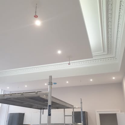 White ceiling with recessed lighting and decorative perimeter